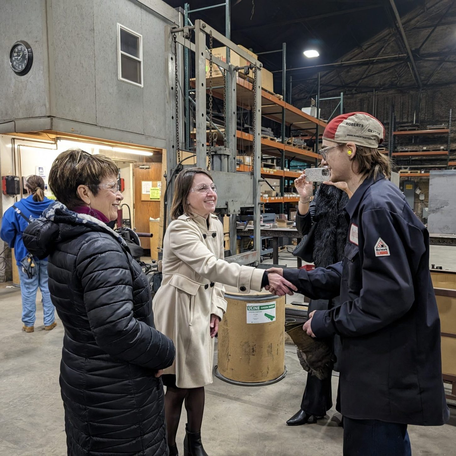 Gwen Ross (Director of Workforce Development Initiatives - Pennsylvania Department of Community & Economic Development (DCED)) and Barb Grandinetti (President of TCP) shake hands with Brandon James (A Graduate From Forest Hills That Got His Position at GapVax Through The Student In The Workplace Inactive at TCP)